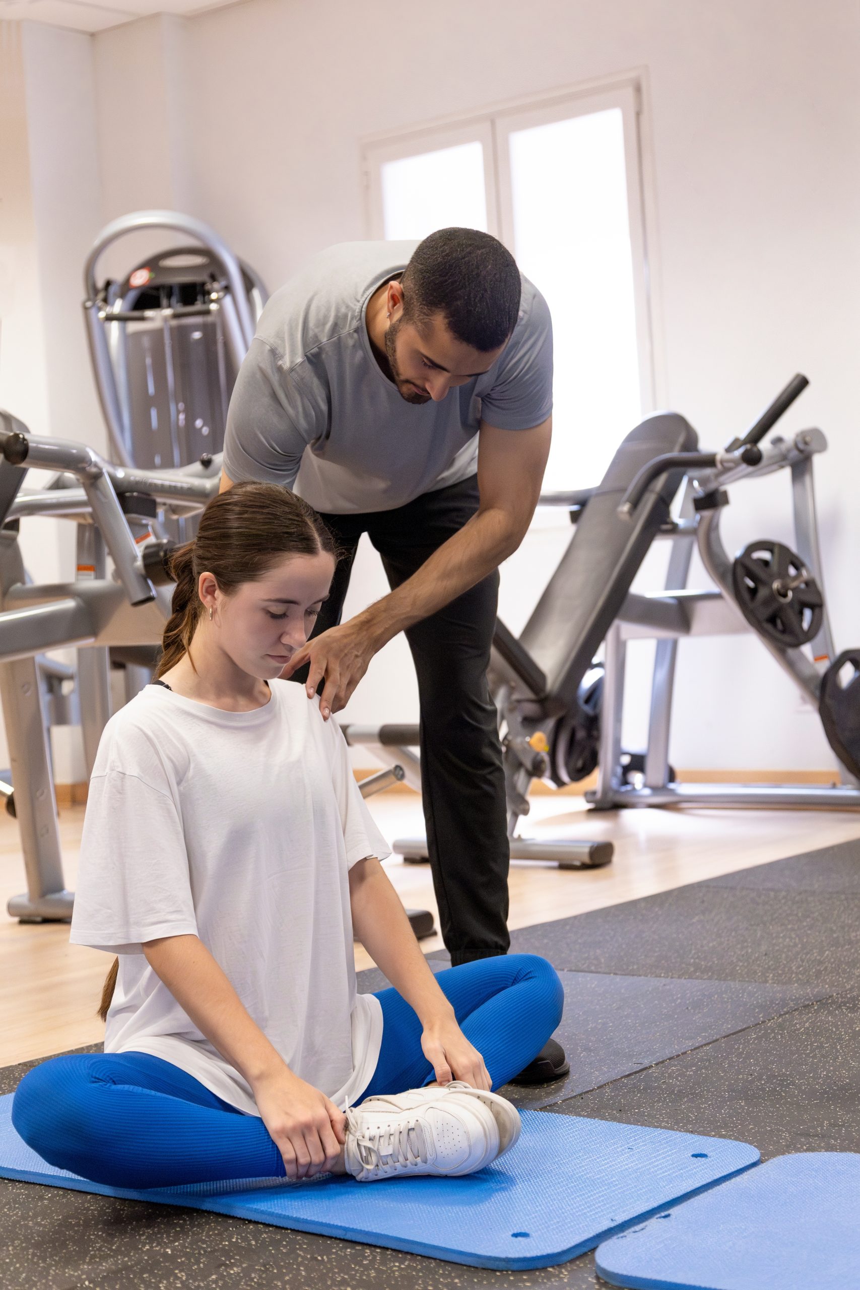 Vertical,Photo,Of,A,Trainer,Correcting,The,Back,Posture,Of